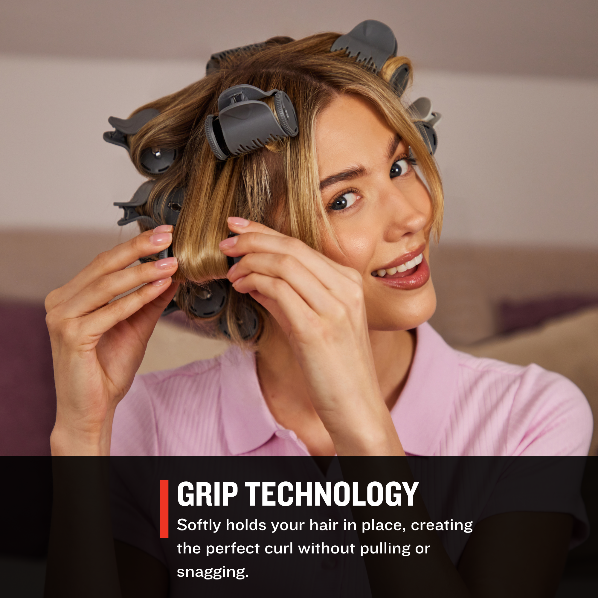 Woman with hair in rollers using grip technology, with a neutral background