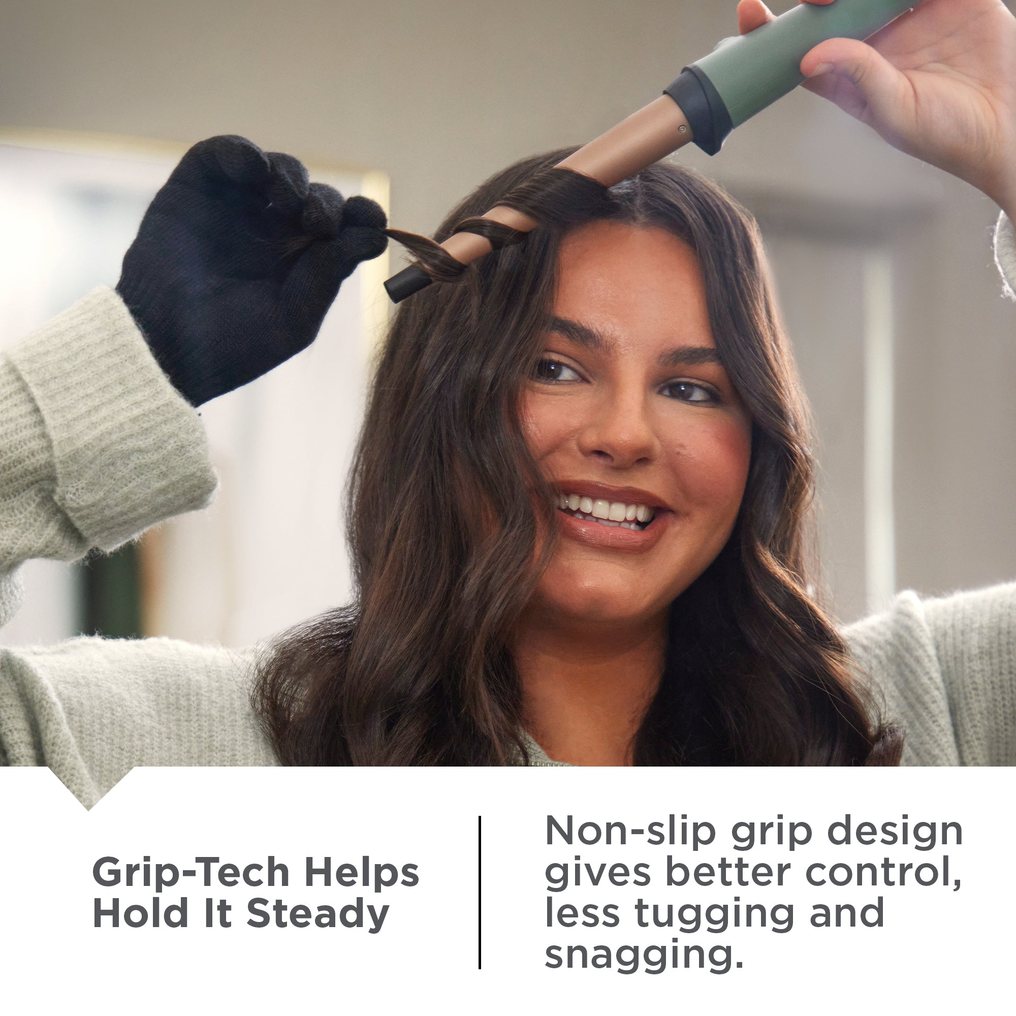 Woman getting her hair styled with a Botanicals™ Tapered Curling Wand wearing gloves, in a home setting.