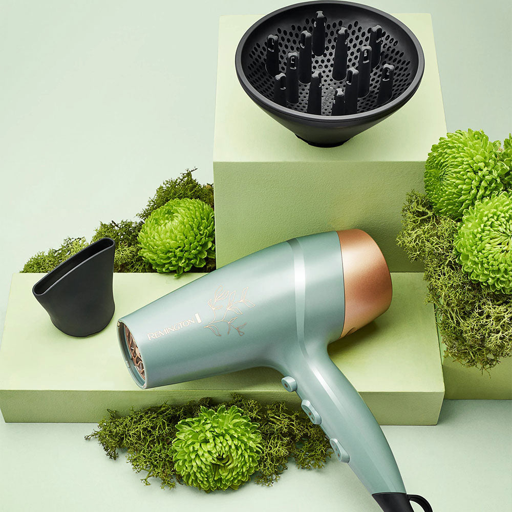 Botanicals™ Hair Dryer with black nozzles on a green and beige geometric background