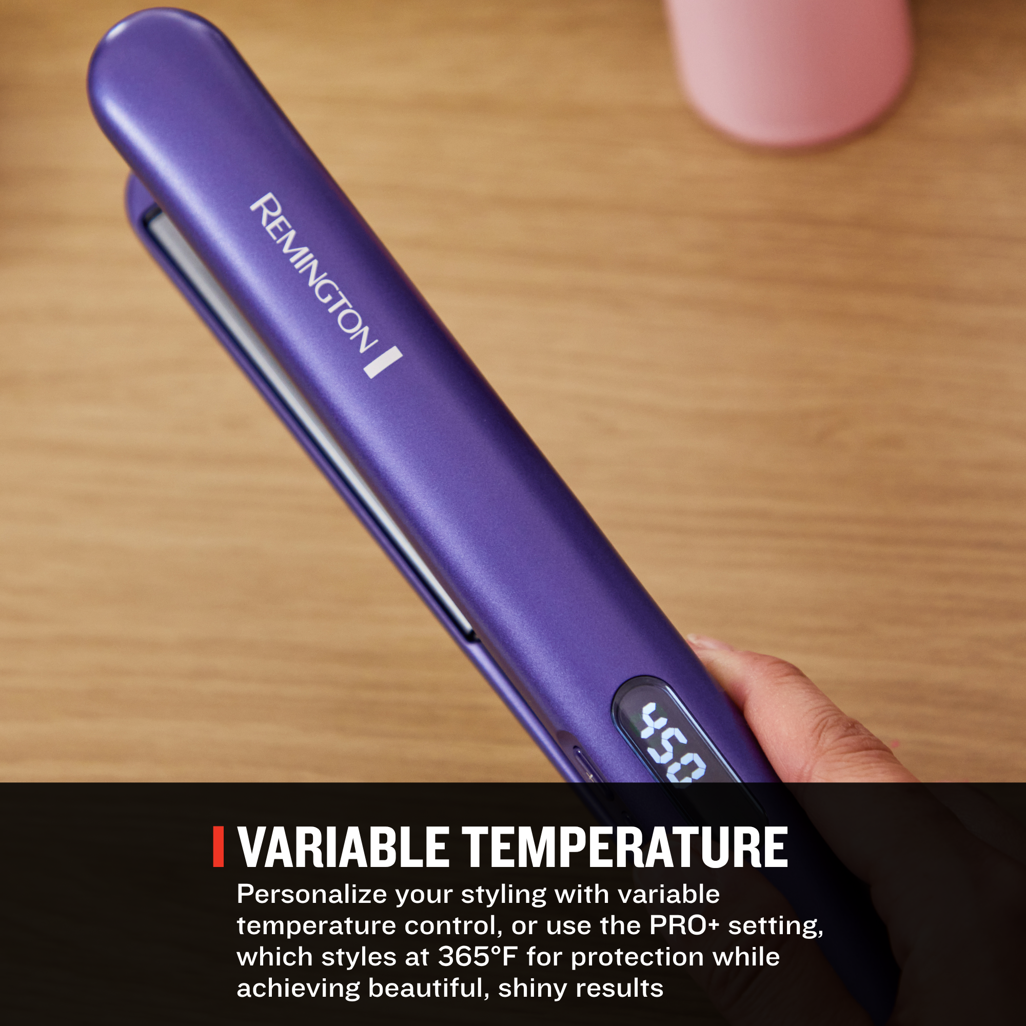 A purple Remington hair straightener is held in a hand over a wooden surface, with a text banner at the bottom highlighting variable temperature styling.