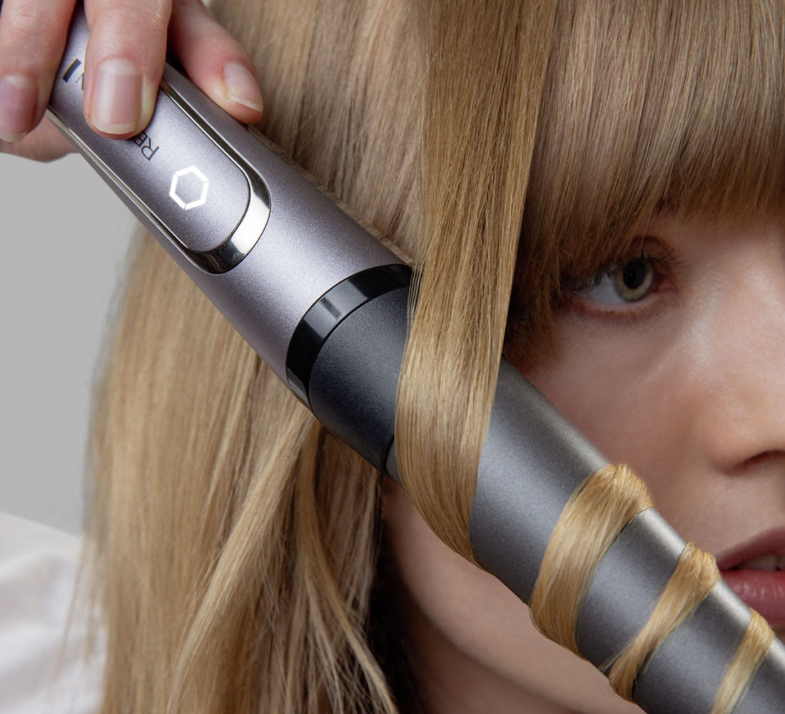 Closeup of woman curling hair