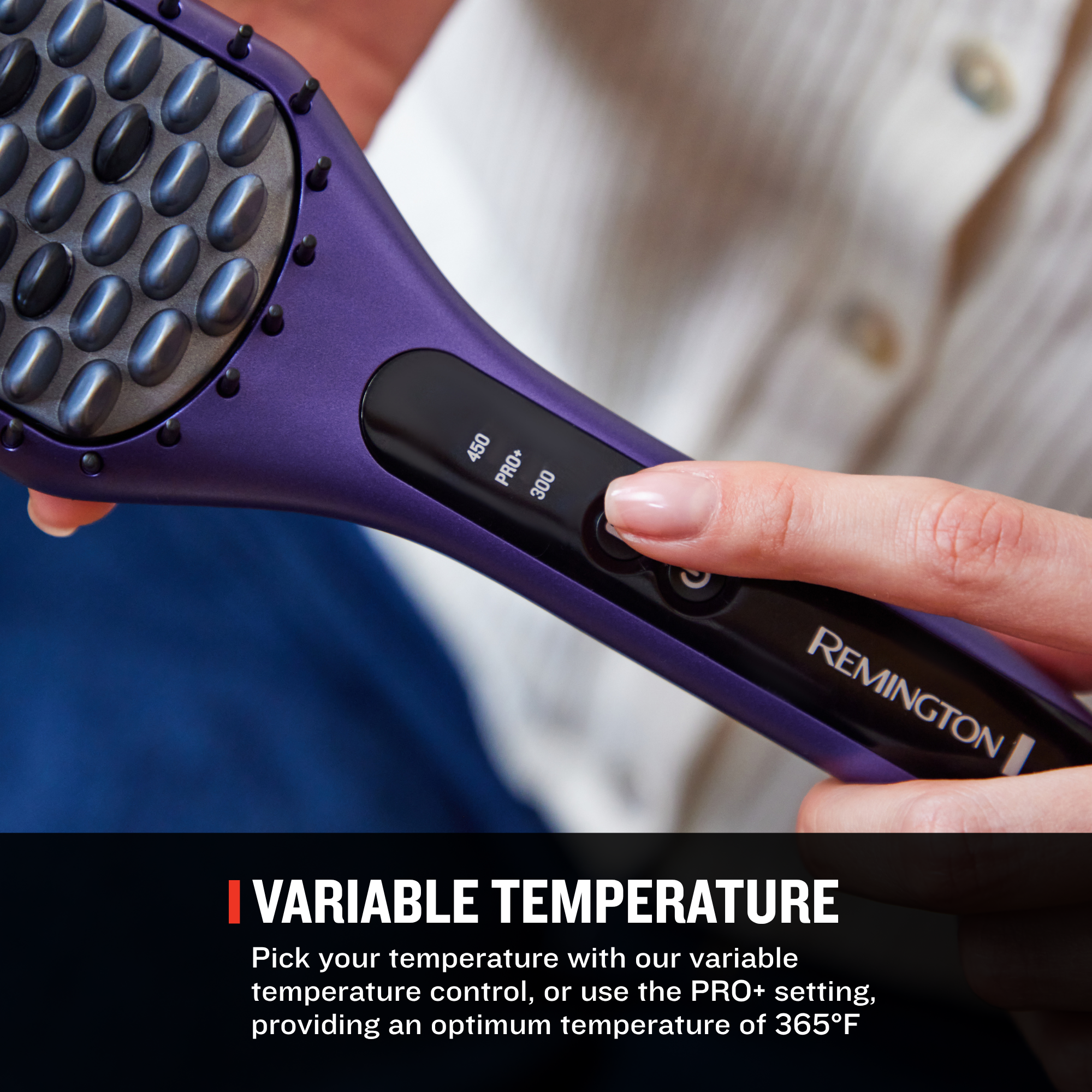 A close-up of a purple and black Remington hair straightener brush being held by a person, with a hand pressing the temperature control. The image includes a text banner at the bottom that reads 'VARIABLE TEMPERATURE' with descriptive copy.