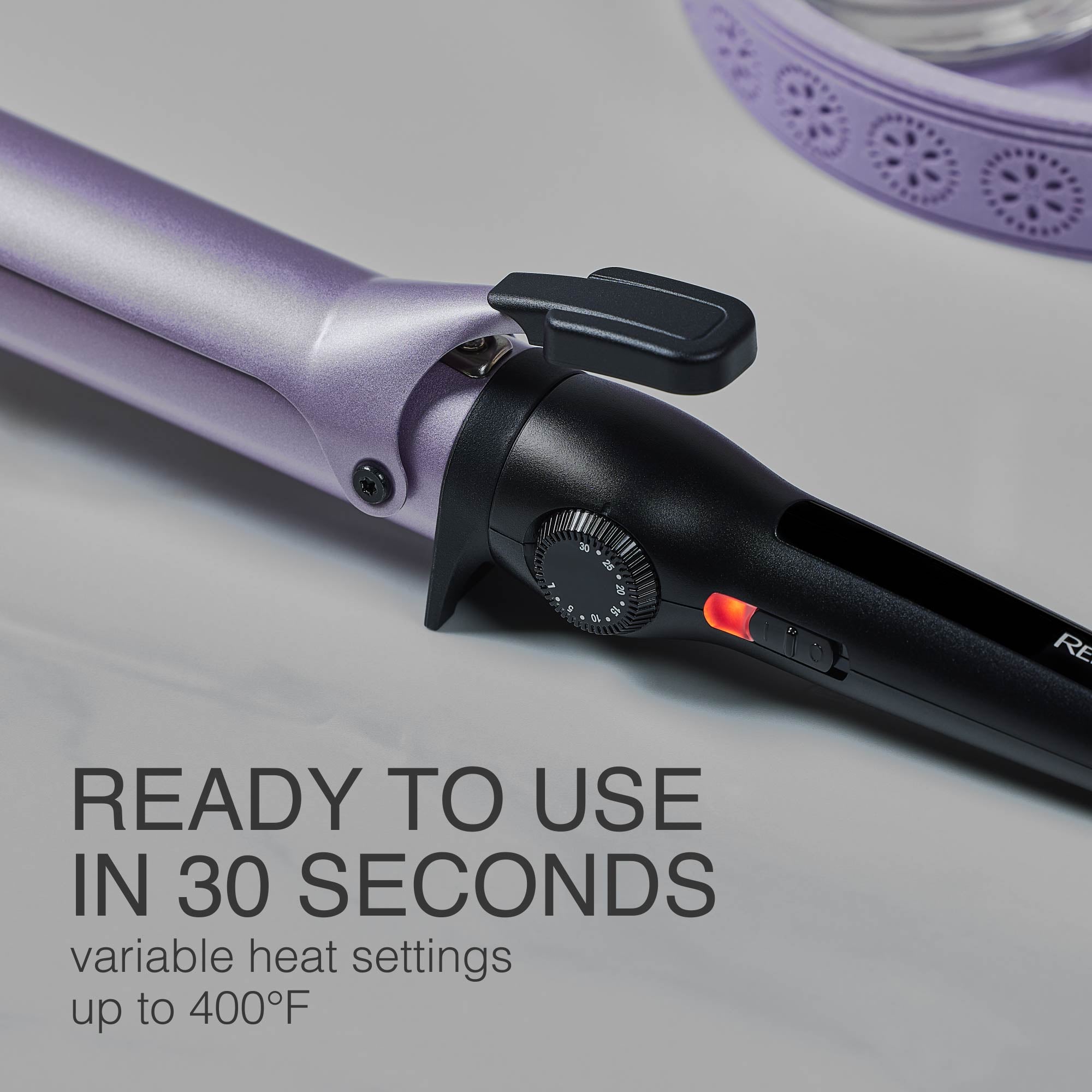 Purple hair curler with black control panel on a gray background