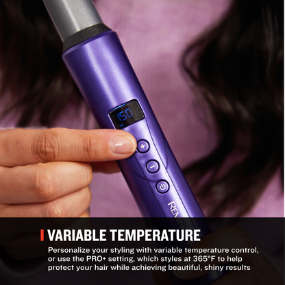 A close-up of a hand holding a purple curling wand with a digital temperature display, shown against a blurred background of dark hair and pink fabric. Text at the bottom reads 'VARIABLE TEMPERATURE' with descriptive copy.