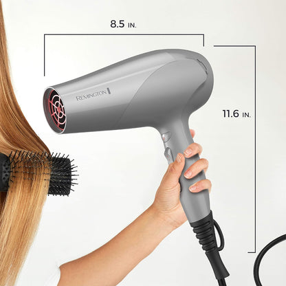 Gray Remington hair dryer being held with measurements indicated on a white background