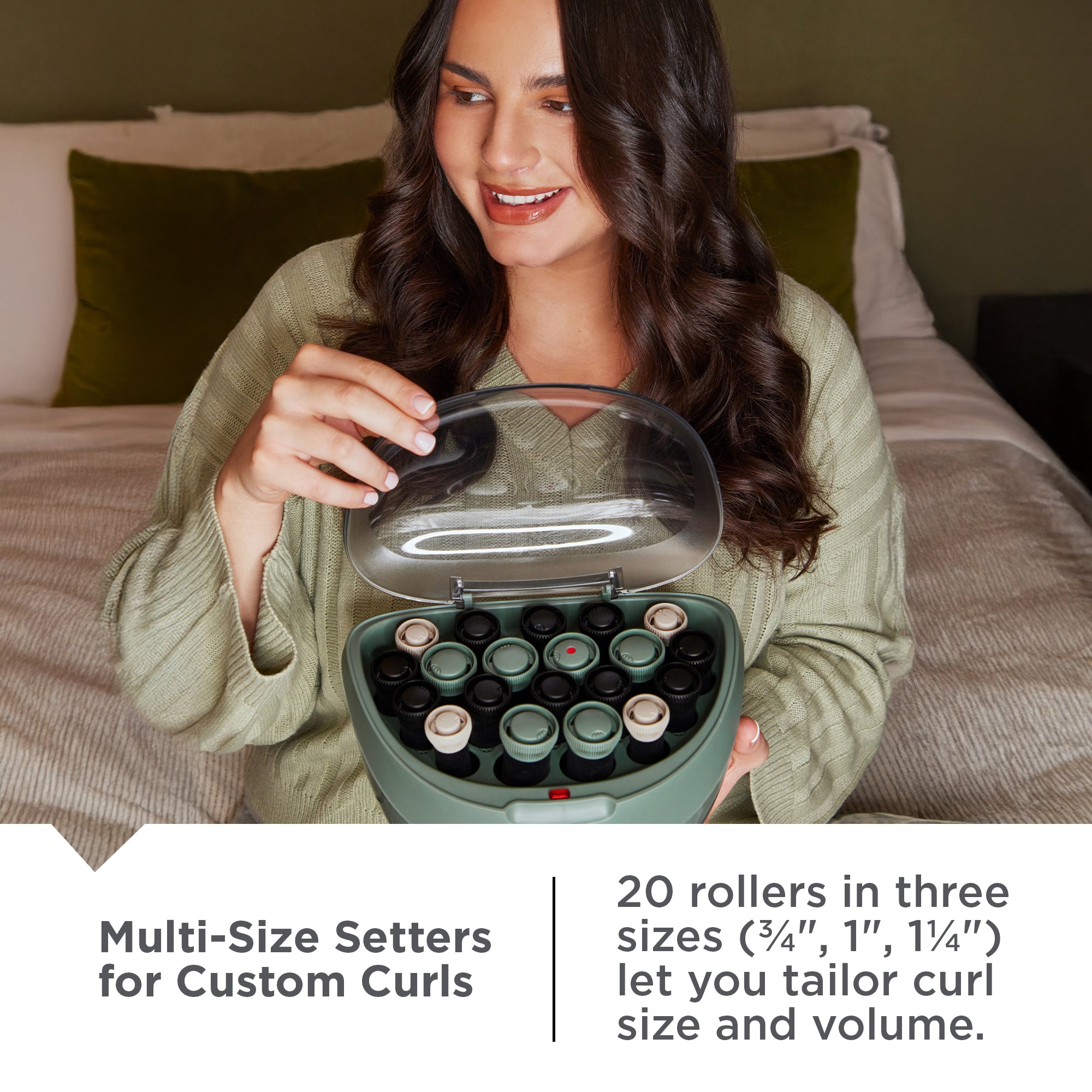 Woman holding a H5750NA Botanicals™ Hair Setters with rollers, sitting on a bed.