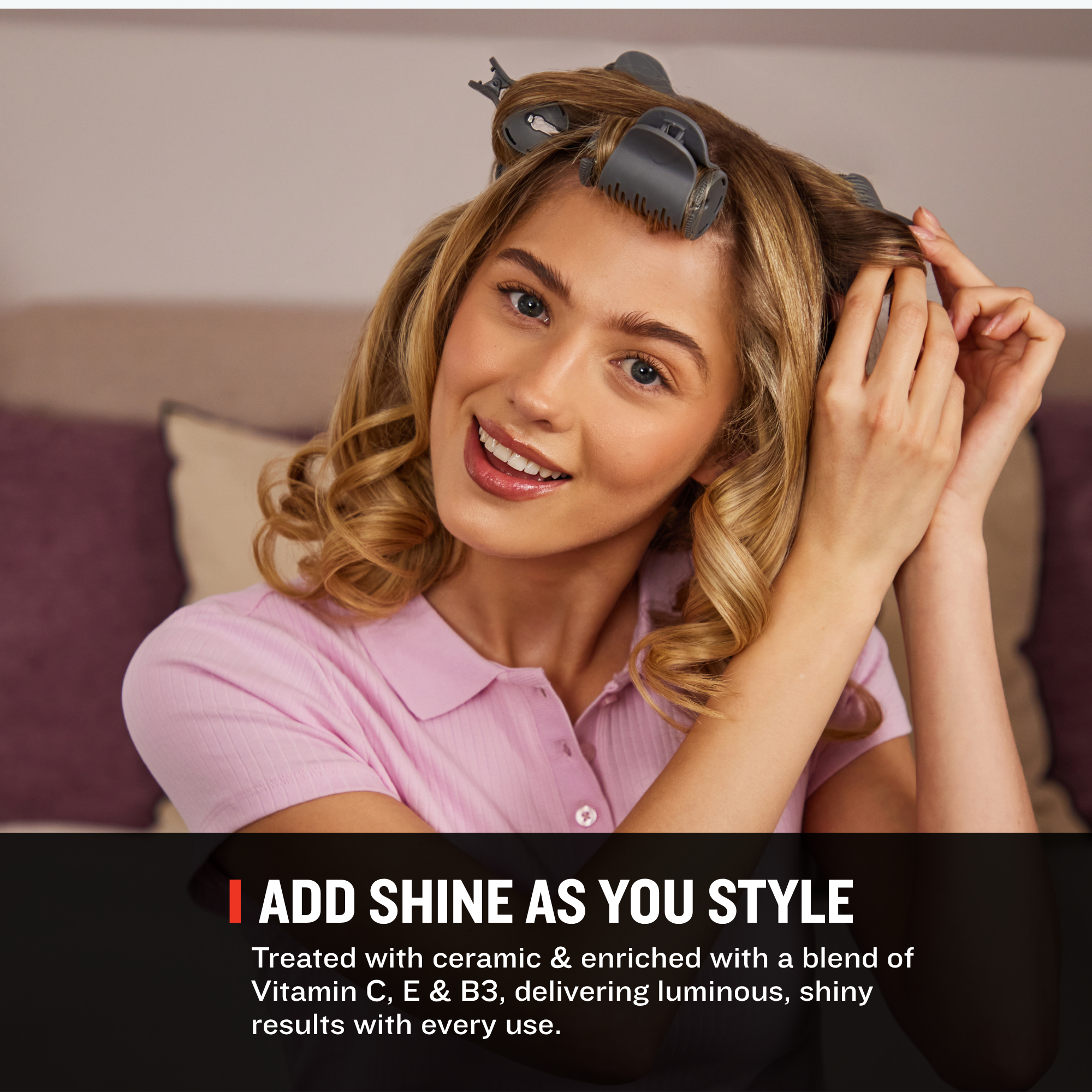 A woman with styled wavy hair wearing a pink polo shirt sits indoors, demonstrating the use of Remington heated rollers. Text at the bottom reads 'ADD SHINE AS YOU STYLE' with additional descriptive copy about treating hair with Vitamin C, E, and B3.