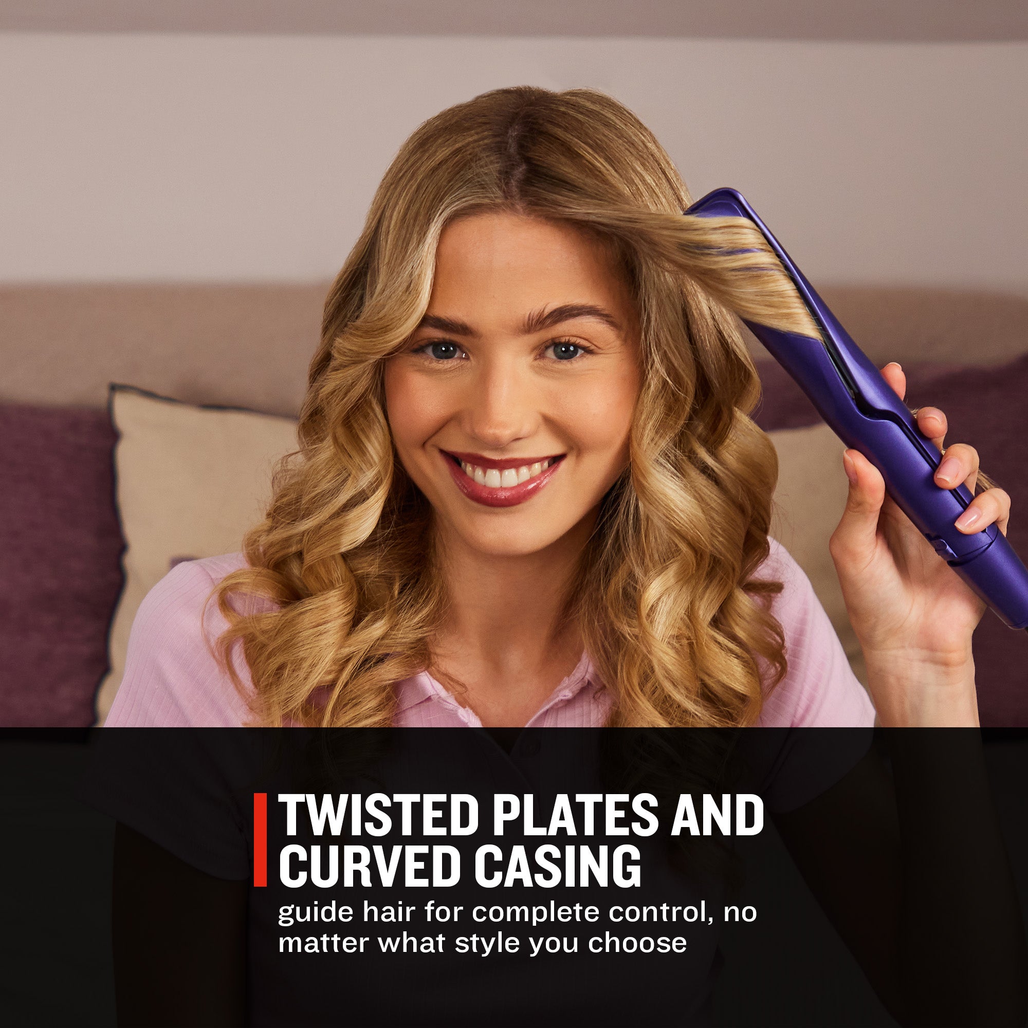 A smiling woman with long wavy blonde hair holds a purple hair styling tool near her hair in a bedroom setting. Text at the bottom reads 'TWISTED PLATES AND CURVED CASING' with smaller descriptive copy.