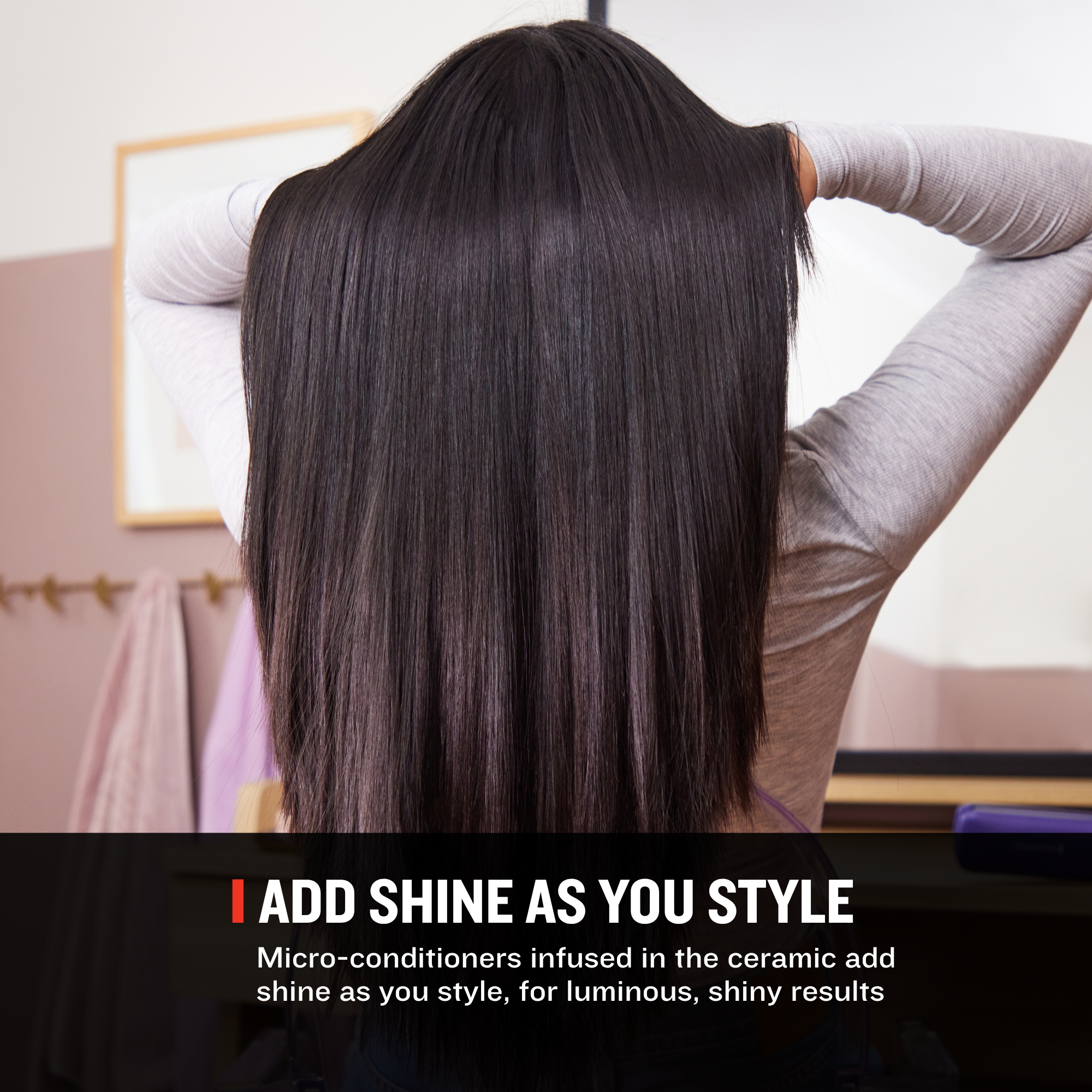 A woman seen from behind with very long, straight, glossy dark brown hair, wearing a light gray long-sleeve top. A text banner at the bottom reads 'ADD SHINE AS YOU STYLE' with smaller descriptive copy about micro-conditioners and ceramic shine enhancement.