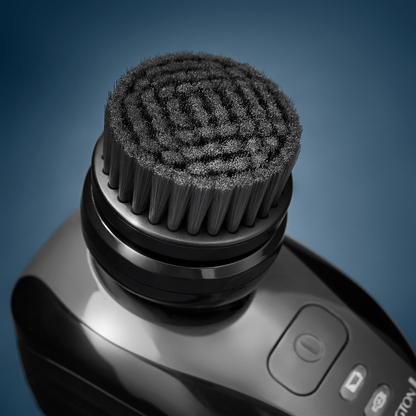 Close-up of a black grooming tool with bristle head on a blue gradient background