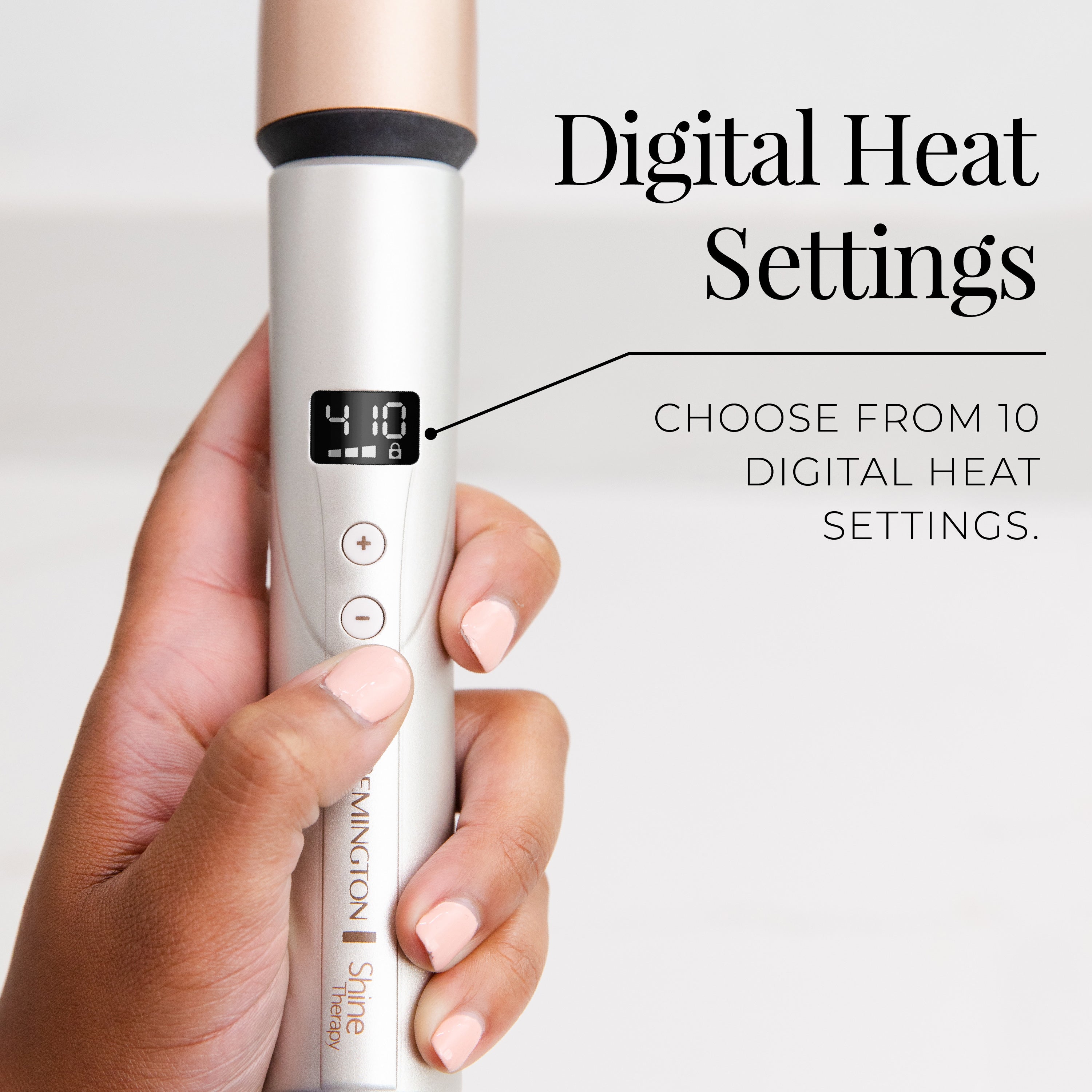 Hand holding a hair styling tool with digital heat settings display, against a white background.