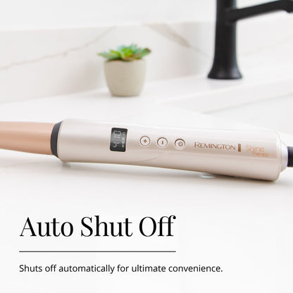 Remington hair straightener on a white surface with a plant in the background