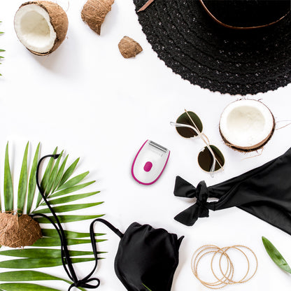 Collection of beach accessories including a black hat, sunglasses, and coconut on a white background with green leaves.